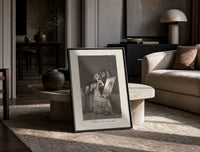 Old woman at vanity mirror print in a black frame leaning on a travertine table in a sunlit lounge