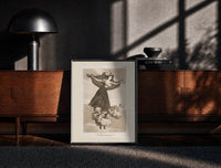 Black-framed Flying woman above three men print on a moody console with designer coffee-table books