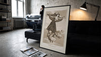 Flying woman above three men print in a slim black frame leaning on a dark sofa in a concrete print studio