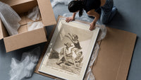 Grotesque demons and goat figure framed print being unpacked from protective bubble wrap and a box