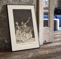 Grotesque nude figures under night sky print in a black frame leaning beside a vintage door on parquet