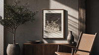Grotesque nude figures under night sky poster framed above a fluted sideboard beside an olive tree