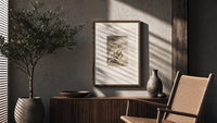 Grotesque figures carrying woman aloft poster framed above a fluted sideboard beside an olive tree