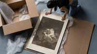 struggling figures with flying witches framed print being unpacked from protective bubble wrap and a box