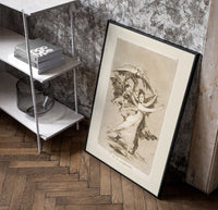 Woman fleeing winged demons poster in a black frame leaning beside a shelf in a raw-plaster loft