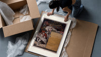 Medieval herald on white horse with trumpet framed print being unpacked from protective bubble wrap and a box