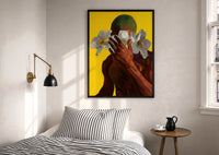 Green Hair with White Flowers print in a black frame above a bed with striped linens, a brass wall lamp and a sunlit window