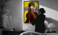 Green Hair with White Flowers print in a slim black frame being hung on a sunlit wall in a monochrome room