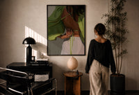 Green Tie-Back Blouse and White Trousers print in a black frame on a sunlit wall with a viewer