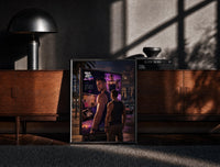 Black-framed muscular man in tank top print on a moody console with designer coffee-table books
