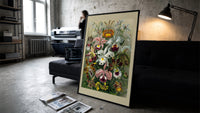 Colorful orchid flowers botanical illustration print in a slim black frame leaning on a dark sofa in a concrete print studio