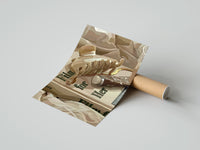 Gently curled Hair Claw and Cosmetic Tube print beside its protective shipping tube
