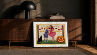 Two children bobbing for apples print in a black frame leaning against a walnut console in lamplight