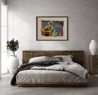 Clown bobbing for apples print in a dark wood frame above a rattan bed on a plaster wall