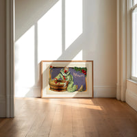 Clown bobbing for apples print in an oak frame on a sunlit wood floor beneath tall window light