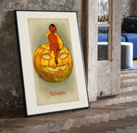 Red devil sitting on jack-o-lantern print in a black frame leaning beside a vintage door on parquet