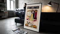 Couple embracing beside grandfather clock print in a slim black frame leaning on a dark sofa in a concrete print studio