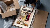 Couple embracing beside grandfather clock framed print being unpacked from protective bubble wrap and a box