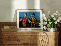 Witch and pumpkin man walking print in an oak frame on a farmhouse dresser beside white tulips