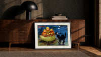 Anthropomorphic pumpkin heads and black cat print in a black frame leaning against a walnut console in lamplight