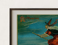 Close-up of the Witch flying on broom with black cat print's dark wood frame corner and archival matte paper