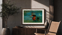 Witch flying on broom with black cat print in a wood frame above a fluted sideboard beside an olive tree