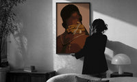 Hand Holding Layered Chains print in a slim black frame being hung on a sunlit wall in a monochrome room