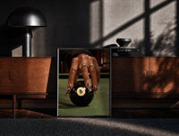 Black-framed Hand on the Eight Ball print on the floor in front of a dark wooden console
