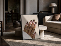 Hand with Brown Swirl Nails print on the floor, leaning against a travertine table