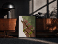 Black-framed Hand with Green Nails and Rings print on the floor in front of a dark wooden console