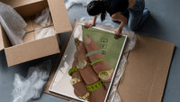 Hand with Green Nails and Rings framed print being unpacked from protective bubble wrap and a box