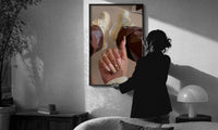 Heart Nail Designs print in a slim black frame being hung on a sunlit wall in a monochrome room