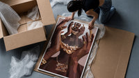 Hands Holding an Ornate Mirror framed print being unpacked from protective bubble wrap and a box