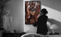 Hands Holding an Ornate Mirror print in a slim black frame being hung on a sunlit wall in a monochrome room
