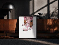 Black-framed Pink Low-Tops print on the floor in front of a dark wooden console