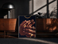 Black-framed Hands with Gold Rings on Navy print on the floor in front of a dark wooden console
