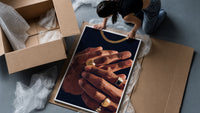 Hands with Gold Rings on Navy framed print being unpacked from protective bubble wrap and a box