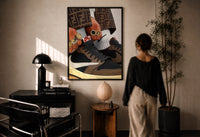 Hands with Rings and High-Top Sneakers print in a black frame on a sunlit wall with a viewer