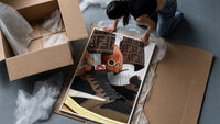 Hands with Rings and High-Top Sneakers framed print being unpacked from protective bubble wrap and a box