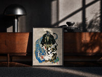 Black-framed Hannya mask samurai beside a blue tiger print on a moody console with designer coffee-table books