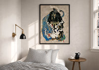 Hannya samurai and blue tiger print in a black frame above a bed with striped linens, a brass wall lamp and a sunlit window