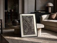 Nude witches with cauldron flying goat print in a black frame leaning on a travertine table in a sunlit lounge