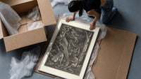 Nude witches with cauldron flying goat framed print being unpacked from protective bubble wrap and a box
