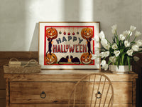 Halloween jack-o-lanterns and black cats print in an oak frame on a farmhouse dresser beside white tulips