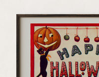 Close-up of the Halloween jack-o-lanterns and black cats print's dark wood frame corner and archival matte paper