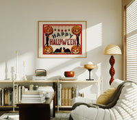 Halloween jack-o-lanterns and black cats print in an oak frame above a mid-century book console with a vintage radio