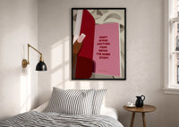Healing Is a Journey Book Page print in a black frame above a bed with striped linens, a brass wall lamp and a sunlit window