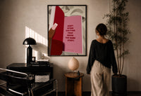 Healing Is a Journey Book Page print in a black frame on a sunlit plaster wall, a woman looking on beside a mushroom lamp