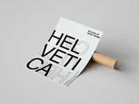 Unrolled Helvetica Swiss design art print resting on a concrete surface with minimalist black lettering