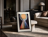 Golden sun with pyramid of colors print in a black frame leaning on a travertine table in a sunlit lounge